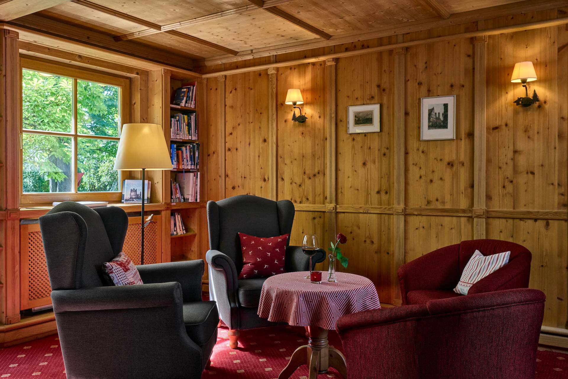 Kachelofenstube mit Bibliothek – Hotel Alpenhof Gauting